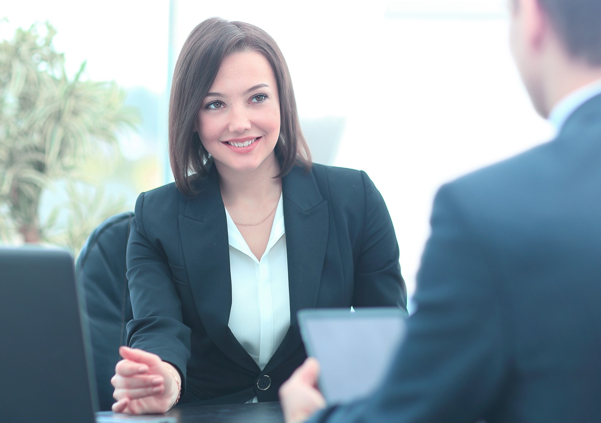 Beautiful young businesswoman conducting a job interview seated at her desk